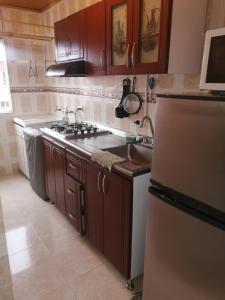 a kitchen with a stove and a sink and a refrigerator at Apartamento a 20 minutos del aeropuerto in Bogotá