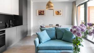 a living room with a blue couch and a table at Lion Apartments - SCALA City Center Studio&Apartments IIC in Gdańsk