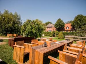 un grupo de bancos y mesas de madera en un patio en Campingplatz Johannisberg, en Fehmarn