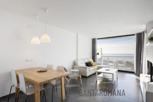 sala de estar con mesa y sofá en Santa Romana Apartments & Suites en Caldes d'Estrac