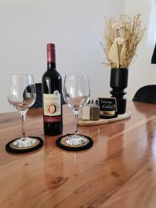 a bottle of wine and two wine glasses on a table at Studio apartman Daruvar in Daruvar