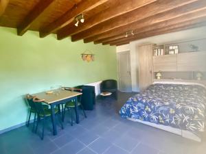 een slaapkamer met een bed en een tafel en stoelen bij Domisiladore in Latouille-Lentillac