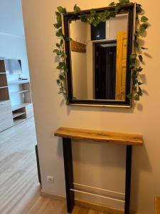 un espejo en una pared junto a una mesa en Baltic Apartament, en Liepāja