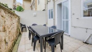 d'une table et de chaises noires sur le balcon. dans l'établissement Cozy Room St Julian's, à Il-Gżira