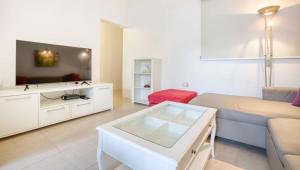 a living room with a couch and a flat screen tv at Cozy Room St Julian's in Il-Gżira