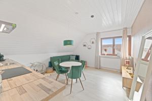 eine Küche und ein Esszimmer mit einem Tisch und grünen Stühlen in der Unterkunft Perouser Wohlfühloase in Rutesheim + 28 Fotos