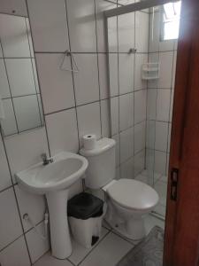 een witte badkamer met een toilet en een wastafel bij HOTEL DIVINO PAI ETERNO 2 in Aparecida