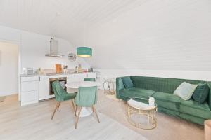 ein Wohnzimmer mit einer grünen Couch und einem Tisch in der Unterkunft Perouser Wohlfühloase in Rutesheim