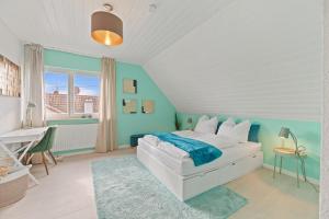 1 dormitorio con cama blanca y pared azul en Perouser Wohlfühloase, en Rutesheim