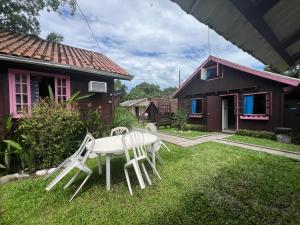 einen Tisch und Stühle im Hof eines Hauses in der Unterkunft Pousada Voo Livre - Ilha do Mel in Ilha do Mel