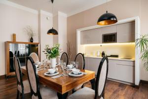 a dining room with a wooden table and chairs at Topolowa Residence LoftAffair Collection in Krakow