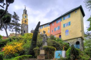 uma estátua em frente a um edifício com uma igreja em Portmeirion Village & Castell Deudraeth em Porthmadog