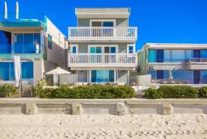 a building on the beach next to the sand at Rip Tide in San Diego