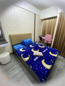 RawabugelにあるAPARTEMENT TRANSPAK JUANDA By Enjoy Roomのベッドルーム1室(青い掛け布団付きのベッド1台付)