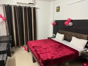 古爾岡的住宿－Staykr Rooms & BnB，一间卧室配有一张带红色毯子和气球的床。
