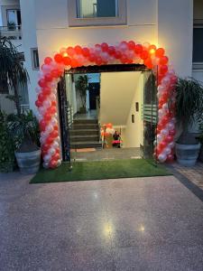une arche avec ballons rouge et orange devant un bâtiment dans l'établissement Staykr Rooms & BnB, à Gurgaon