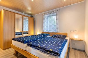 a bedroom with a bed with blue sheets and a window at Haus Monterosa in Baden-Baden