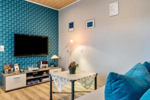 ein Wohnzimmer mit einem Sofa und einem TV an der Wand in der Unterkunft Haus Monterosa in Baden-Baden