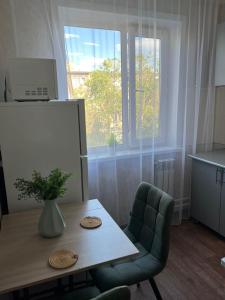 a kitchen with a table with a vase on it at Уютная двушка в центре in Temirtaū