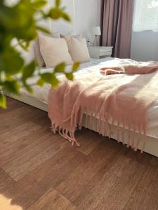 a bedroom with a bed and a wooden floor at Уютная двушка в центре in Temirtaū