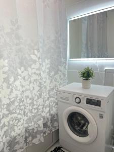 a washing machine in a bathroom with a window at Уютная двушка в центре in Temirtaū