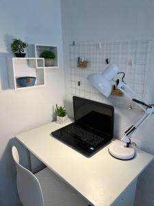 a laptop computer sitting on a white desk with a lamp at Уютная двушка в центре in Temirtaū +8 photos