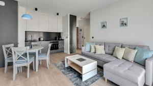 a living room with a couch and a table and a kitchen at Lion Apartments - SCALA City Center Apartments&Studio IIIB in Gdańsk