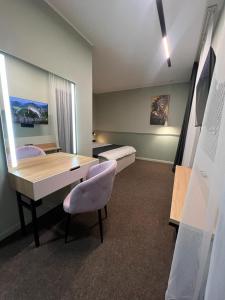 Cette chambre comprend un bureau, une table et un lit. dans l'établissement Caspian Marine Hotel, à Aktau