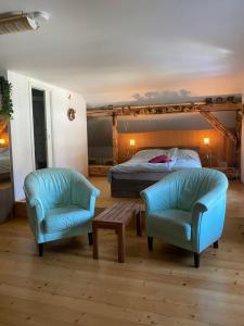 a bedroom with a bed and two chairs at Droom b&b Čermná in Čermná