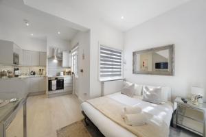 1 dormitorio blanco con 1 cama y cocina en Livestay Tranquil Studio Retreat in Harrow, en Harrow