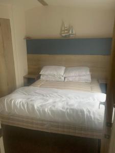 Elle comprend un grand lit avec des draps et des oreillers blancs. dans l'établissement Hill Top 22 - Blue Dolphin, à Gristhorpe