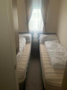 - 2 lits jumeaux dans une chambre avec fenêtre dans l'établissement Hill Top 22 - Blue Dolphin, à Gristhorpe