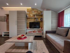 a living room with a couch and a table at Apartman Tiva - Milmari Resort-garažno mesto-GRATIS in Kopaonik