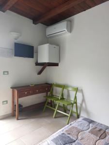 a bedroom with a bed and a desk and a green chair at Oltremare in Vignacastrisi +42 photos