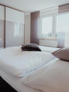 een groot wit bed in een slaapkamer met 2 kussens bij Ferienwohnung Morgensonne in Appenweier