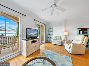 een woonkamer met een televisie en een balkon bij Holder D in Beach Haven