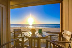 einen Tisch und Stühle auf einem Balkon mit Blick auf den Strand in der Unterkunft Salt Life in San Diego