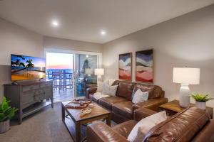 a living room with a leather couch and a tv at Salt Life in San Diego