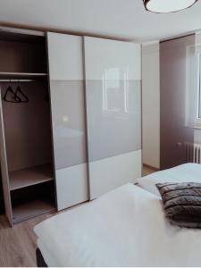 a bedroom with a white bed and a closet at Ferienwohnung Morgensonne in Appenweier