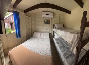 ein kleines Zimmer mit 2 Betten und einem Fenster in der Unterkunft Pousada Voo Livre - Ilha do Mel in Ilha do Mel