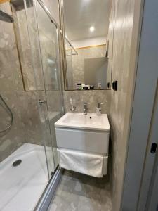 y baño con lavabo y ducha. en Caspian Marine Hotel en Aktau