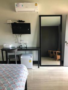ein Schlafzimmer mit einem Spiegel, einem Tisch und einem Bett in der Unterkunft Sleep@819 รีสอร์ท in Ban Sam Phrao