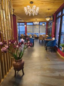 een eetkamer met een vaas met bloemen erin bij Caspian Marine Hotel in Aqtau
