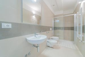 a white bathroom with a sink and a toilet at Residence Padulella "Due" in Portoferraio