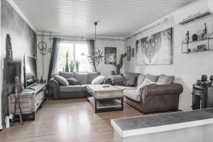 a living room with a couch and a table at Guestly Homes - 4BR Cozy House near windfarm in Piteå