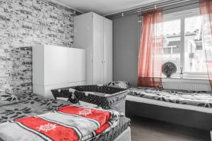 1 Schlafzimmer mit 2 Betten und einem Fenster in der Unterkunft Guestly Homes - 4BR Cozy House near windfarm in Piteå
