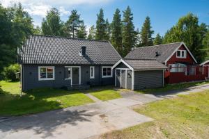 a house with a red house at Guestly Homes - 4BR Cozy House near windfarm in Piteå