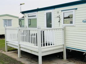a white mobile home with a white deck at Golden Sands in Skegness