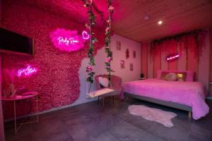 a pink bedroom with a bed and a pink wall at Pinky Room in Saint-Julien