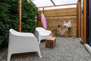 a patio with two white chairs and a bike at Pinky Room in Saint-Julien